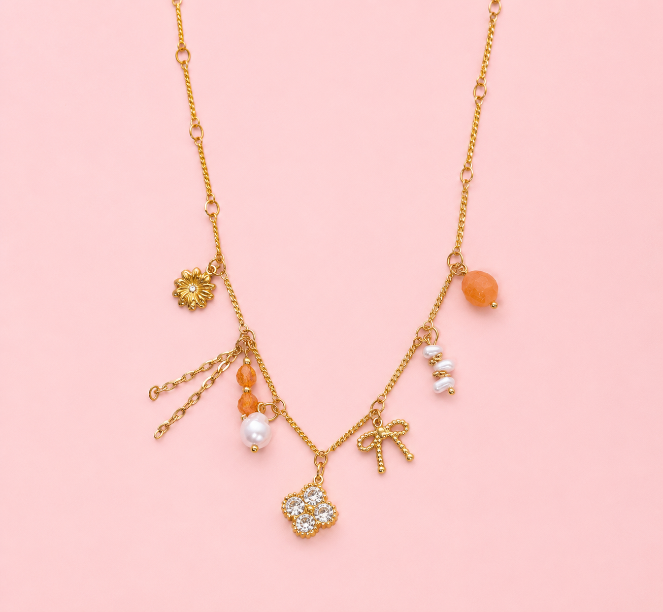 Néréa - Collier doré à charms perles oranges, nœud et fleur strassée