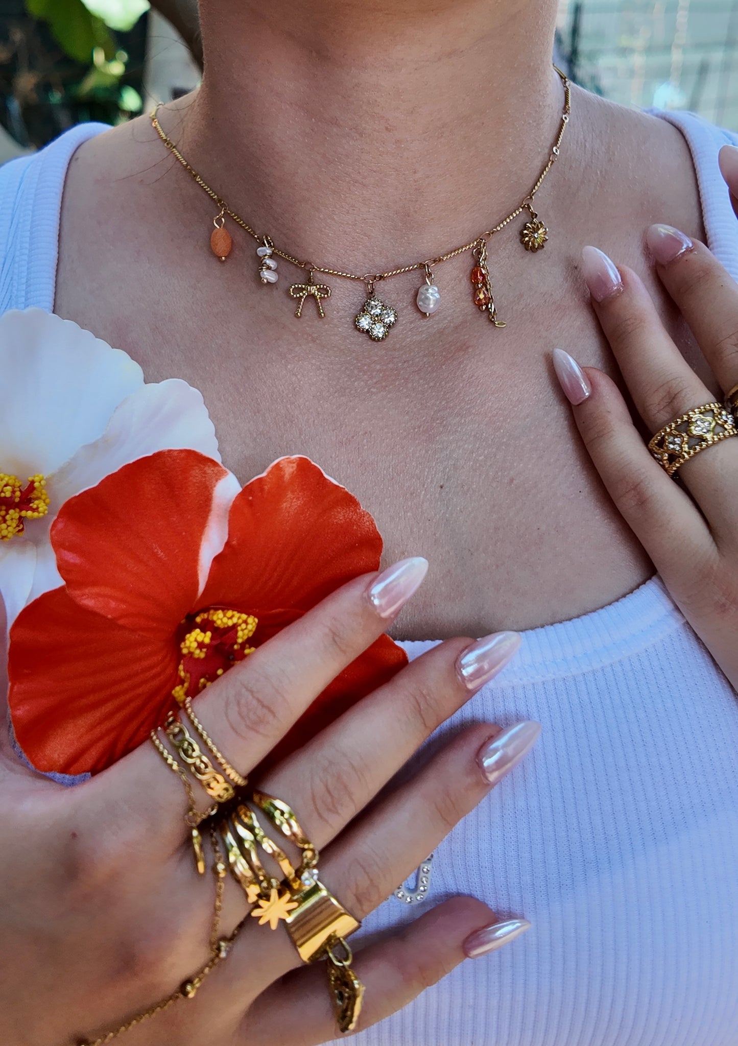 Néréa - Collier doré à charms perles oranges, nœud et fleur strassée